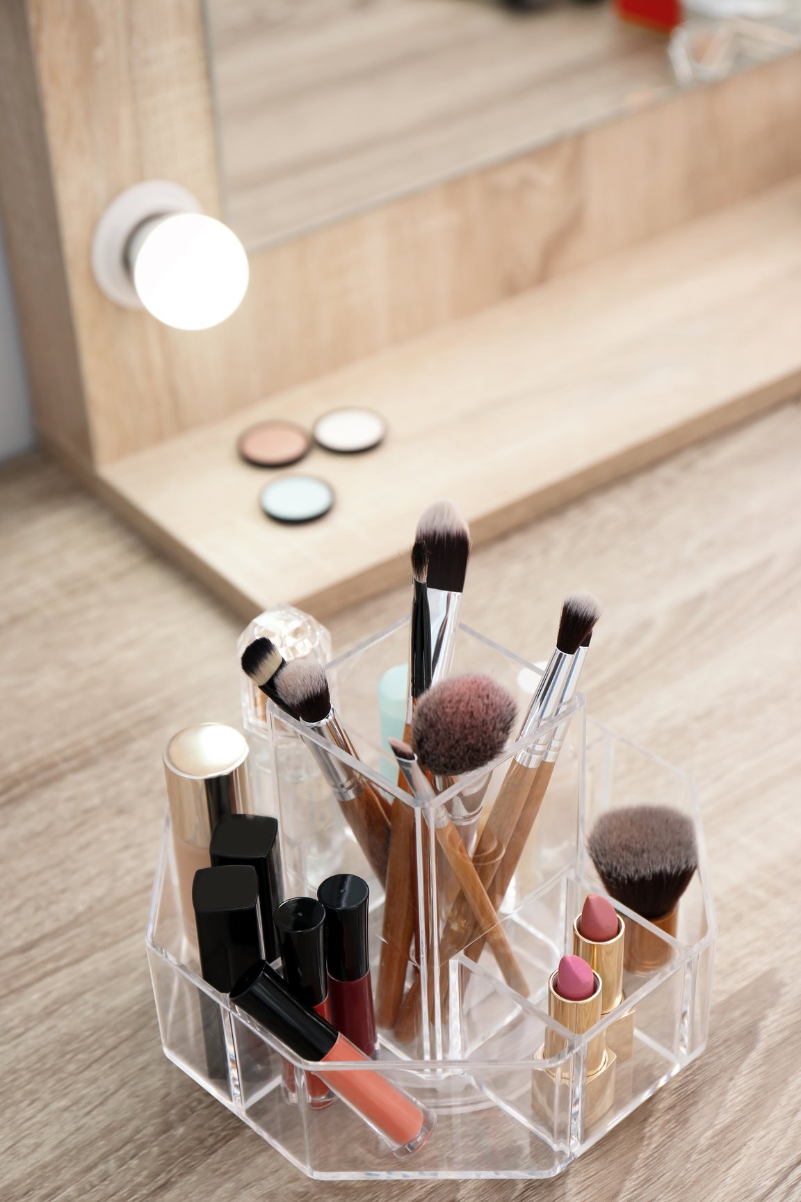 Organizer with Cosmetic Products for Makeup on Table near Mirror